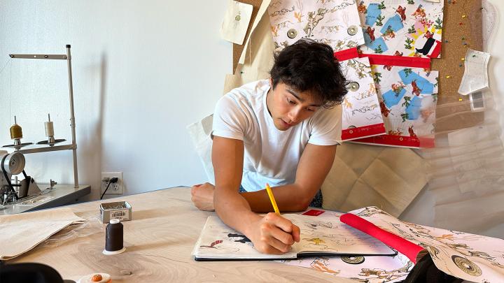 Designer standing at desk working on design of Jimmy Dean Griddle bags